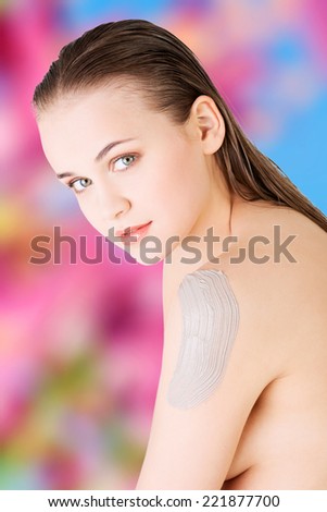 Beautiful face of spa woman with healthy clean skin and clay mask on arm.