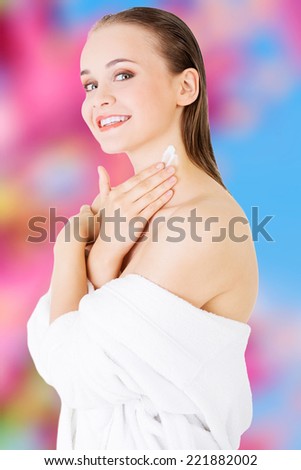 Beautiful woman with healthy skin applying cosmetic cream on a clean fresh face