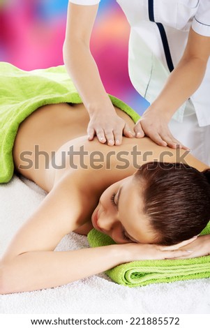 Beautiful woman lying on bed in spa salon having massage. Spa concept.