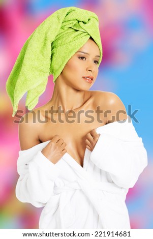 Attractive woman wrapped in towel with turabn. She is showing her shoulders.