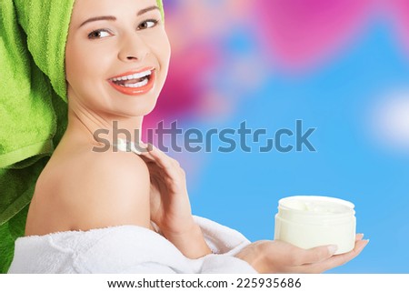 Happy woman applying cream on shoulders