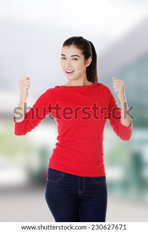 Happy ,excited young woman with fists up