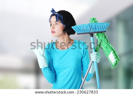 Happy cleaning woman showing copy space