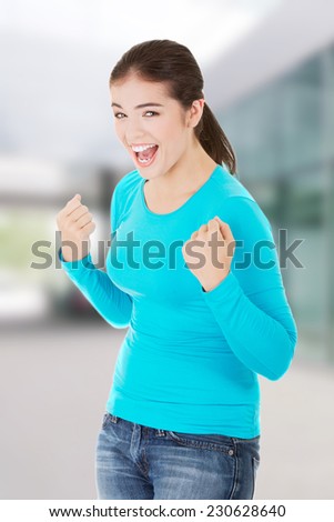 Excited happy success young woman with fists up.