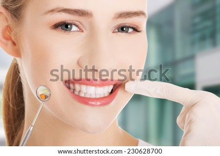 Young doctor or dentist with dental mirror and glove Young doctor or dentist with dental mirror and glove