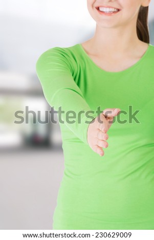 Beautiful young adult woman about to shake hands