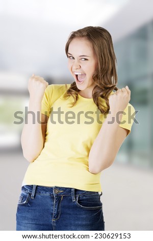 Excited happy success young woman with fists up