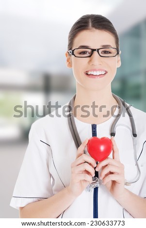 Beautiful young female doctor holding a heart