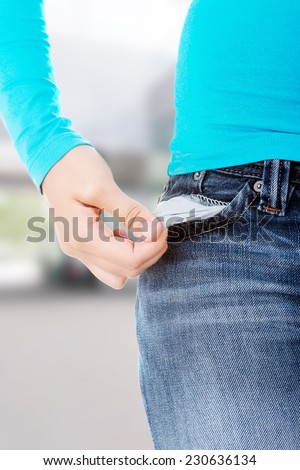 Teenage girl standing and showing her empty pockets.