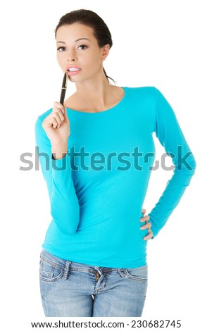 Young woman holding a pen in mouth.