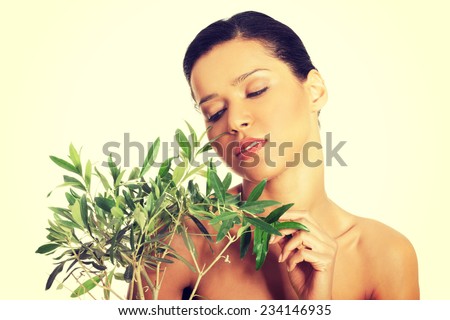 Portrait of beautiful young exotic woman with health skin and with olive tree