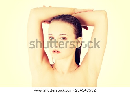 Attractive naked woman with her hands above head. Isolated on white.