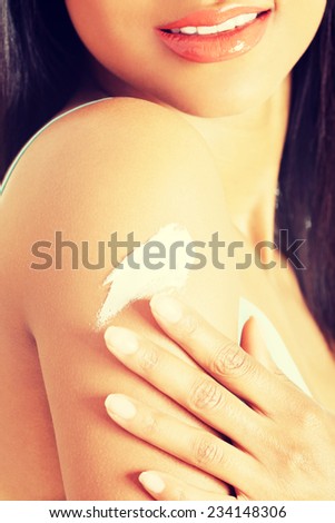 Beautiful woman with healthy skin applying cosmetic cream on a clean fresh arm