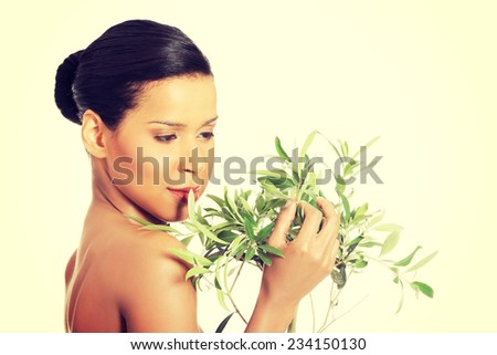 Portrait of beautiful young exotic woman with health skin and with olive tree