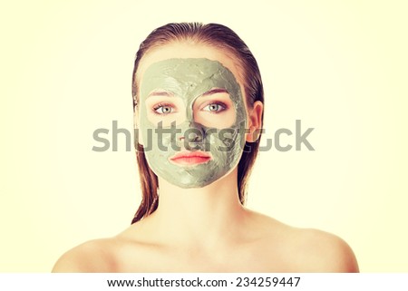 Beautiful woman with green clay facial mask, isolated on white