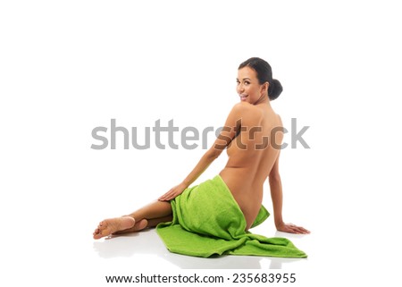 Back view woman sitting wrapped in towel.