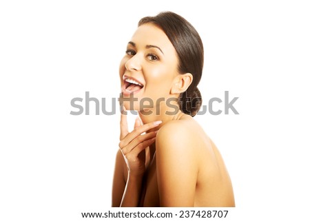 Portrait of nude woman laughing loud, holding finger on chin.