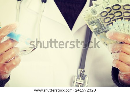 A handsome doctor with money and syringe.