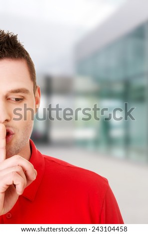 Man gesturing to be quiet with finger