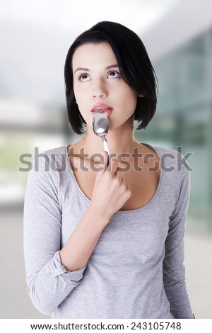 Beautiful woman with spoon in her mouth