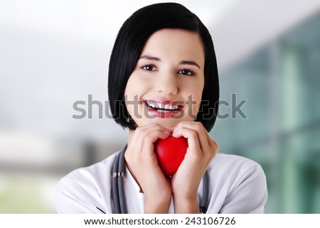 Young female doctor holding heart model