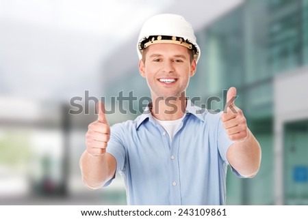 Portrait of a builder in white helmet gesturing OK