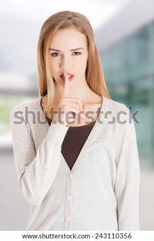 Beautiful woman with finger on lips
