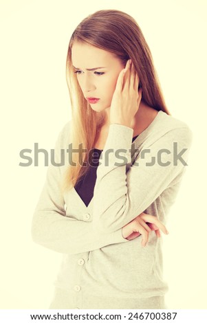 Beautiful casual woman is touching her ear. Health concept.