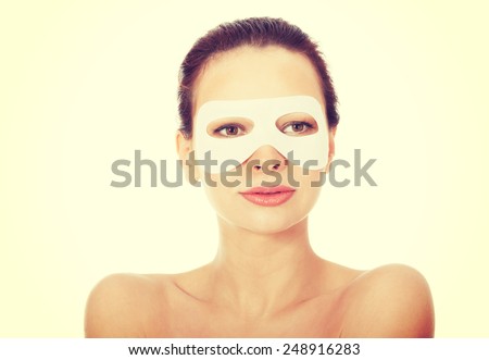 Young beautiful spa woman with collagen eye mask.