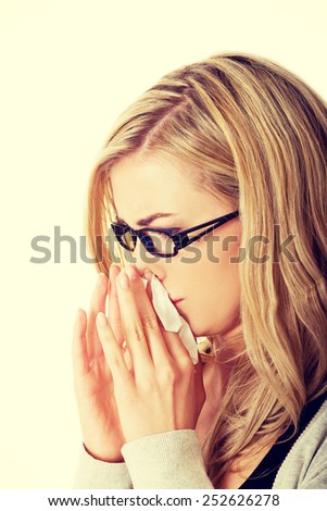 Sick young woman blowing her nose