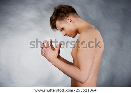 Young shirtless angry man trying to keep calm.