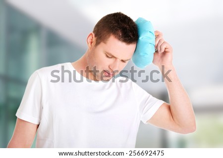 Man with ice bag for headaches.