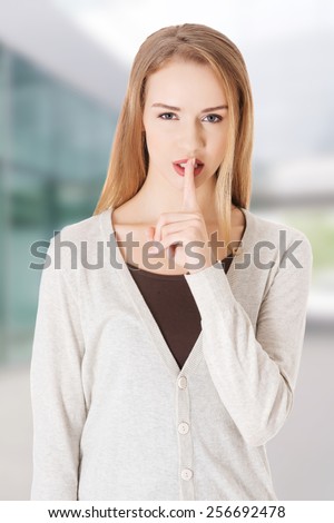 Beautiful woman with finger on lips