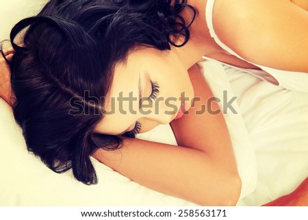 Tired sensual woman sleeping on bed.