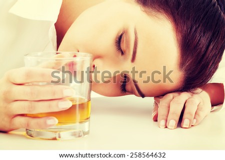 Depressed businesswoman in depression drinking alcohol.