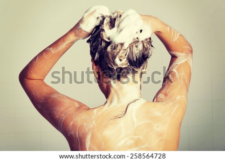 Woman taking a shower and shampooing her hair.