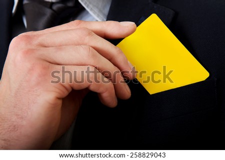 Businessman taking his yellow personal card from pocket.