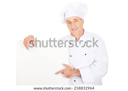 Experienced chef in white uniform holding empty banner.