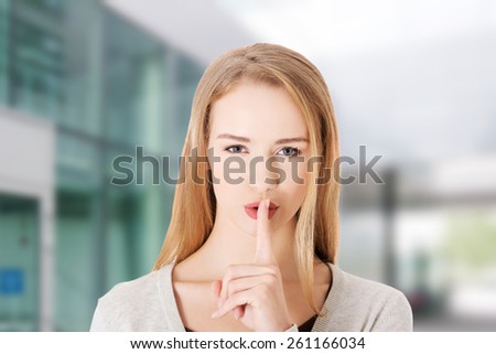 Beautiful woman with finger on lips.