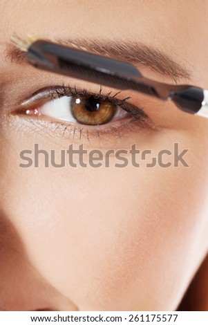 Young woman brushing her eyebrow