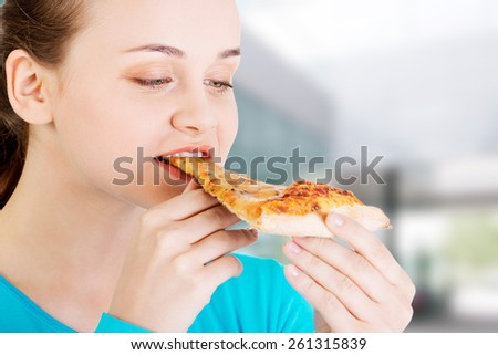 Young beautiful woman eating pizza
