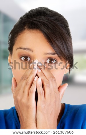 Young scared woman covering the mouth.