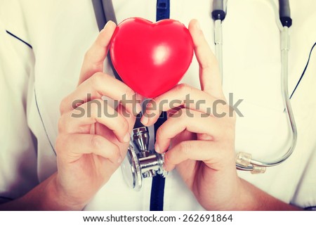 Red heart held by a female doctor. Close up.