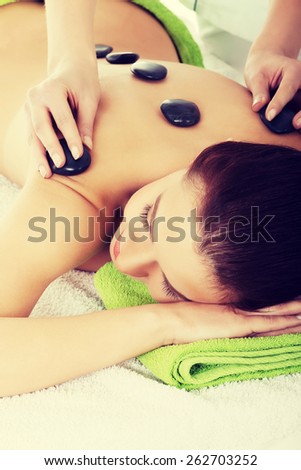 Girl on a stone therapy, hot stone massage.