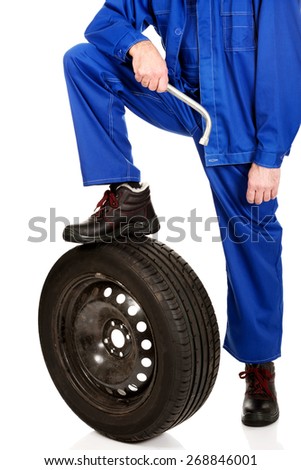Repairman leg in heavy boots on a tire.