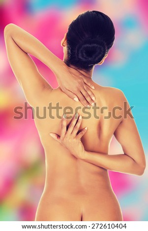 Slim nude woman with back pain