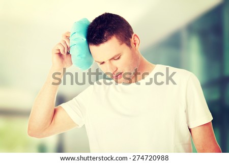 Man with ice bag for headaches.