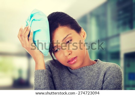 Woman with ice bag having headache.