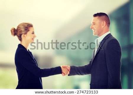 Happy business couple shaking hands