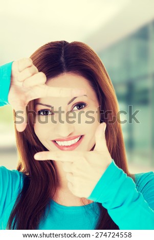 Happy woman gesturing frame sign